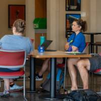 group of four in a lobby discussing